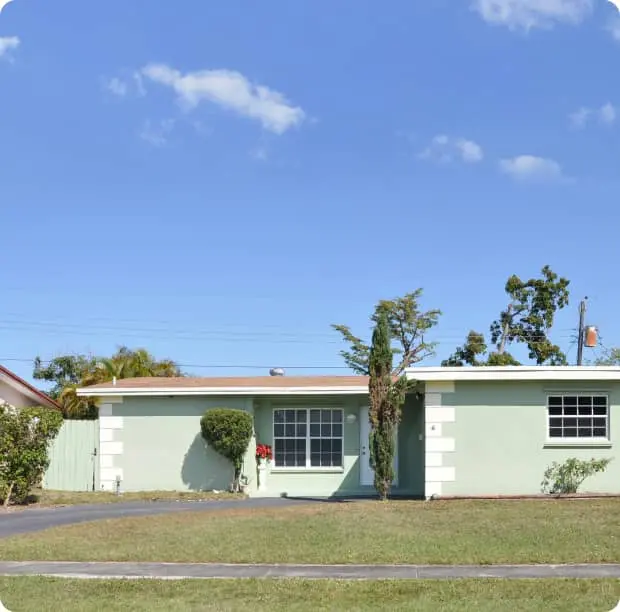 Single-story Florida home with light green walls and a clear blue sky.