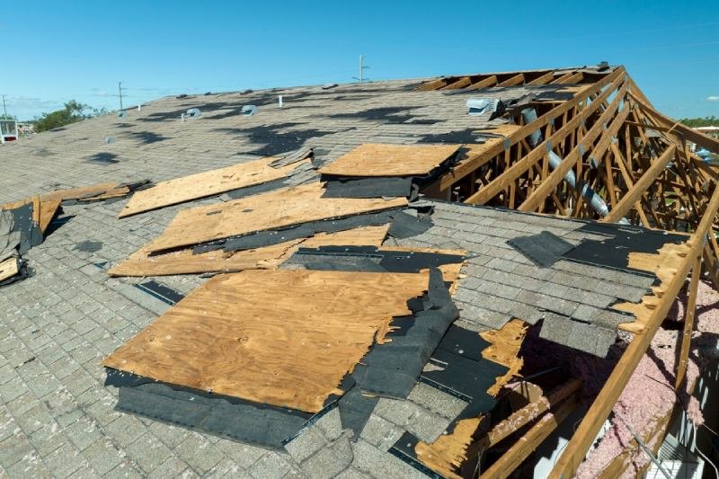 A shingle roof that has been devastated by a hurricane.